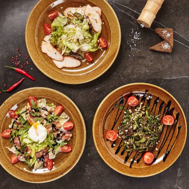 Rustik seramik kaplamalar üstten görünüm çeşitli et salata kümesi. Füme Türkiye'de tatlı sosu, pastırma, haşlanmış yumurta, Dana bonfile, Zeytinyağlı ve balsamik giymiş sedir fındık karışımı salata