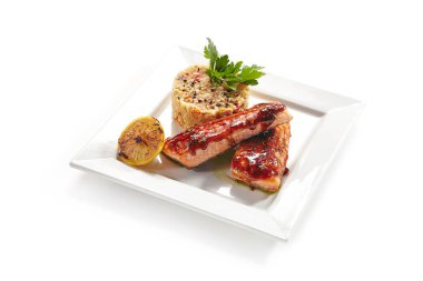 Beyaz arka planda Izole zarif restoran plaka tatlı ve ekşi sos sebzeler ile kızarmış balık. Pişmiş domates, tatlı biber, havuç ve soğan yakın yukarı tüm doğranmış deniz bas