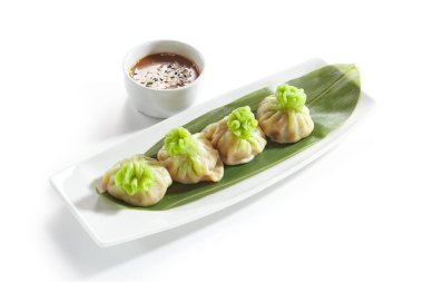 Vejetaryen Dim Sum, Dimsum veya Momos Muz Yaprak Beyaz arka plan üzerinde izole baharatlı sos ile hizmet veren lüks. Çin Restoran Wontons veya köfte makro fotoğraf yakın çekim
