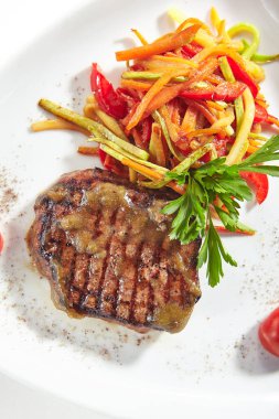 Beyaz arka planda Izole sebzeler ile ızgara Beef Steak Lüks servis yemek. Barbekü dana eti veya Beefsteak yeşillik üst görünümü ile zarif düz plaka üzerinde restoran ana ders