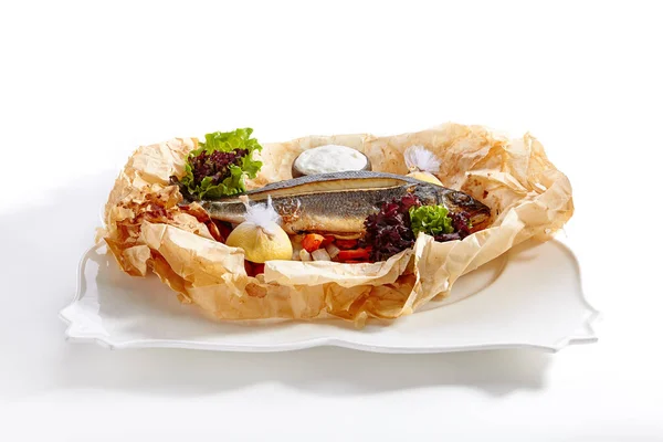 Fish Baked with Tomato Salsa, Greens and Olives Isolated on White Background. Restaurant Exquisite Serving Dish of Whole Grilled Sea Bream Fish on Rustic Paper Close Up