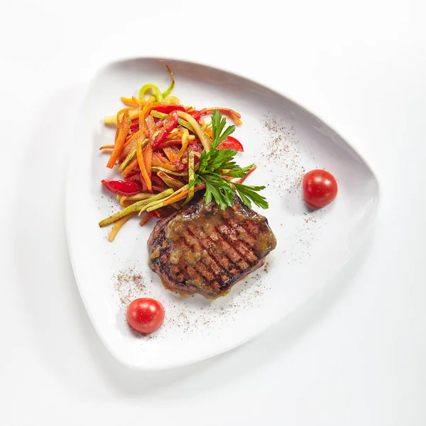 豪华的烤牛肉牛排的菜与蔬菜隔离在白色的背景 餐厅主菜与烤肉小牛肉或牛排优雅的平板与绿色顶视图 — 图库照片