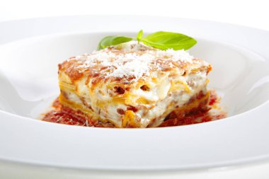 Beyaz arka planda izole edilmiş domates soslu geleneksel İtalyan lazanyası. Sıcak Lezzetli Lazanya veya Parmesan Peynirli Lazanya Zarif Restoran Tabağı Kapalı