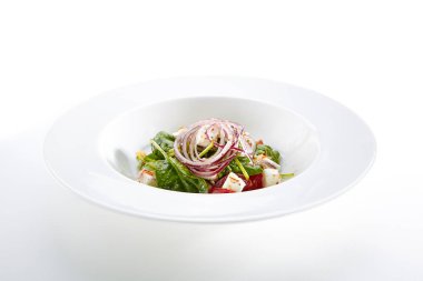 Yeşil salata ile keçi peyniri, ıspanak, domates, beyaz arka plan üzerinde izole kırmızı soğan halkaları. Restoran başlangıç menüsü ile taze Spinacia ve pazı yaprakları, domates, yeşillik, baharat yakın.