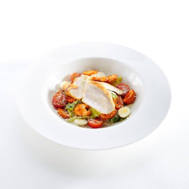 Beyaz arka plan üzerinde izole bir çıtır tavuk ile Sezar salatası. Restoran Ana Kursu hindi fileto, bıldırcın yumurtası, Mini baget Peksimet, Cherry domates, marul yaprakları, sos ve Parmesan peyniri ile