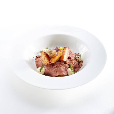 Pişmiş patates ve beyaz arka planda Izole sebzeler ile et dilimleri. Restoran ana ders dilimlenmiş Dana ya da domuz eti, ev yapımı mayonez, yeşillikler ve baharatlar yakın çekim