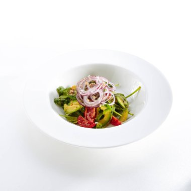 Avokado, domates ve soğan düz restoran salata plaka üzerinde izole beyaz arka plan. Sağlıklı Vitamin Salat dilimlenmiş Alligator Armut, Yeşiller ve baharatlar ile yakın çekim