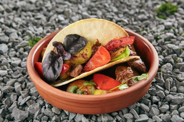 Güzel şarap soslu ve pasta oryantal baharat soslu kuzu Vintage seramik kase hizmet. Orijinal Restoran ev yapımı koyun etli domates, kabak, fesleğen ve rustik arka plan üzerinde gözleme