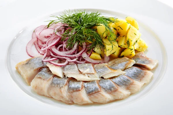 餐厅海鲜菜单上有咸鲱鱼 洋葱圈和煮薯片 在典雅的餐盘上隔开 点缀着绿色莳萝的腌鱼片片 — 图库照片