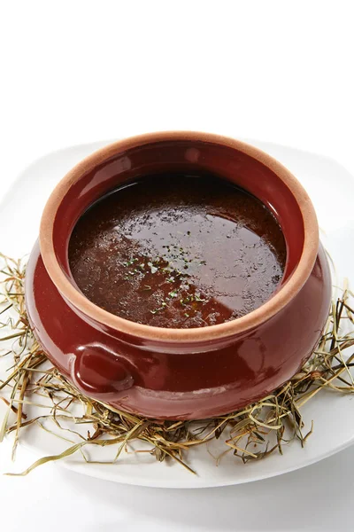 Riche soupe rustique en pot d'argile sur le foin sec parfumé — Photo