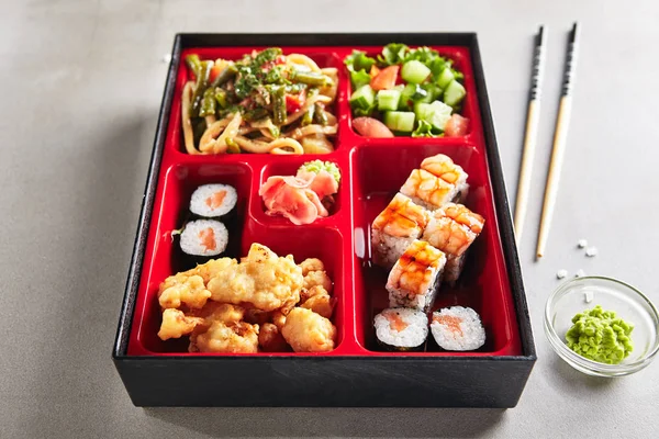 Порция свежих продуктов в японском Bento Box с суши-роллами — стоковое фото