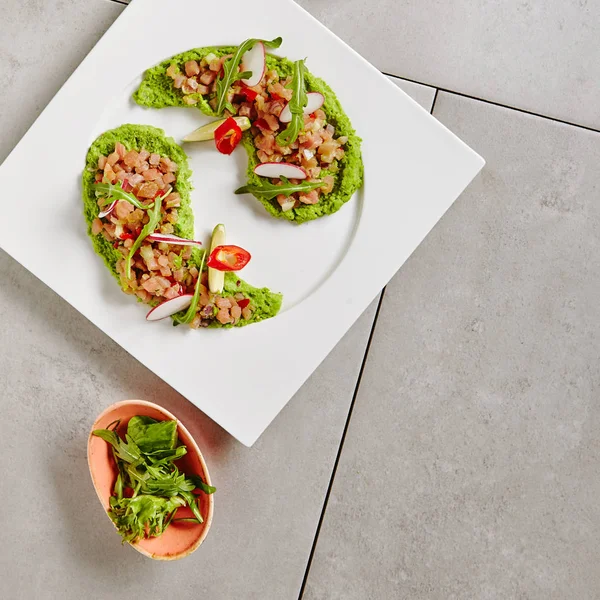 Ahi Thunfisch seviche mit Radieschenscheiben und Rucola auf weißem Teller — Stockfoto