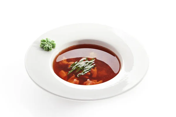 Soupe rouge aux fruits de mer dans une assiette blanche isolée — Photo