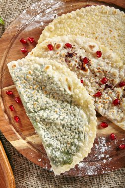 Rustik masa örtüsü çuval bezi zemin üzerine Kutabs grup. Qutab, Kutab veya fırında tavuklu ince haddelenmiş kısaca pişmiş bir dışbükey kalbur üzerinde olan hamuru ile peynir ve yeşillik olduğunu