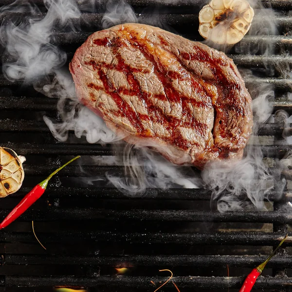 Bife de carne no churrasco chamas Grill fundo — Fotografia de Stock