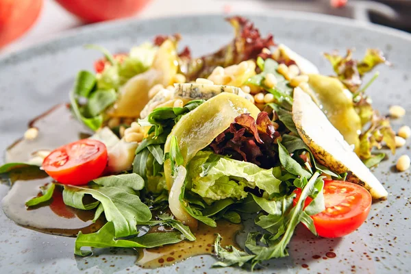 Salat mit geschnittenen Birnen, Gorgonzola-Käse, Gemüse und Pinienkernen — Stockfoto