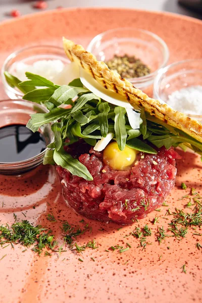 Tartare de bife feito de carne crua com verdes close-up — Fotografia de Stock