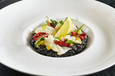 Ahtapot ve güneş kurutulmuş domates ile siyah risotto