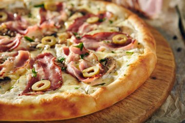 Pizza restoran menü - pastırma ve zeytin ile lezzetli taze Pizza. Pizza malzemelerle rustik ahşap masa üzerinde