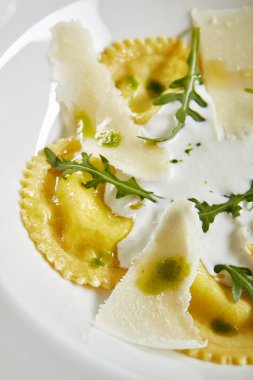 Nefis servis beyaz Restoran plaka ravioli 4 peynirler ile peynir Espoume yakın yukarı. Ispanak ve Arugula yakın yukarı ile geleneksel Incelik Italyan köfte