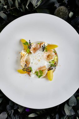 Limon Suyu Top View Köpük altında Avokado Tartare ve Tatlı Biber ile Tiger Karides Enfes Hizmet Restoran Tabağı. Koyu Yapraklar ve Çiçekler Arka Plan Kral Karides Makro Fotoğraf