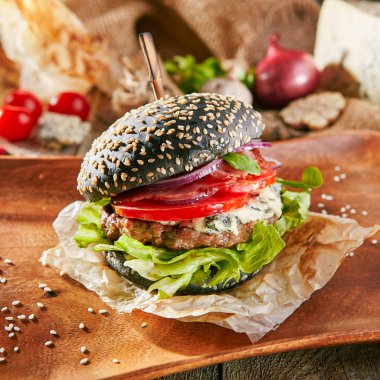 Burger Restoran menü - lezzetli siyah Burger ahşap plaka üzerinde mavi peynirli ızgara. Rustik ahşap masa ve malzemelerin üzerine arka plan