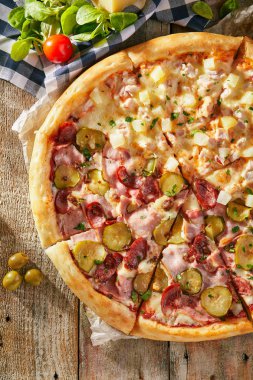 Yarım tavuk ve ananas başka bir sosis üzerinde sebze yaprakları ve zeytin ile kurullarında doğranmış pizza