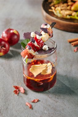 Cam kavanozda chokeberry reçel i ve şiş üzerinde pişmiş elma ile Sonbahar tatlısı. Kırmızı meyve sonbahar marmelatı veya siyah rowan confiture seçici odak ile yakın