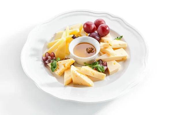 白いレストランPに蜂蜜、ナッツ、ブドウのチーズ盛り合わせ — ストック写真