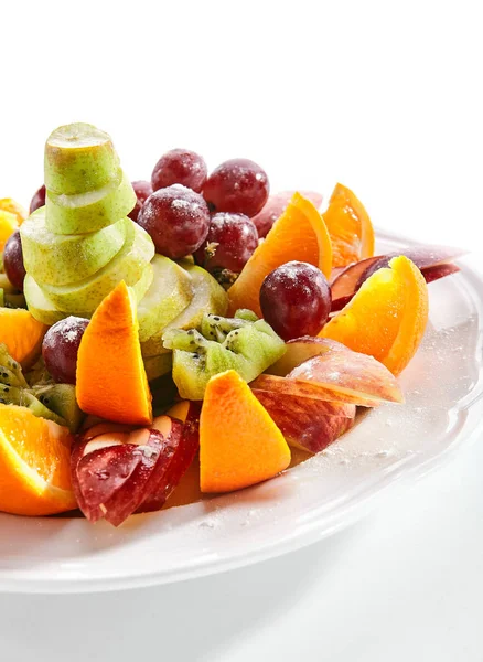 Fruit schaal met oranje wiggen, appel, druiven, kiwi en peer — Stockfoto