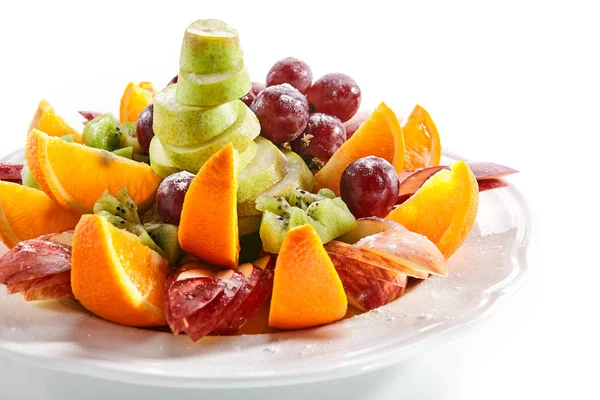 Frukttallrik med apelsin klyftor, äpple, vindruvor, kiwi och päron — Stockfoto