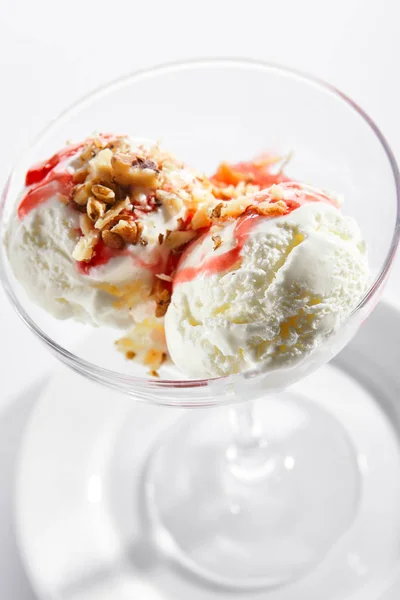 Dvě zmrzlinové koule nebo ledová smetana s jahodovou omáčkou a ořechy — Stock fotografie