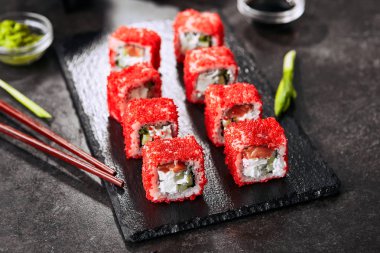 Pirinç, krem peynir, somon, salatalık, uçan balık havyar ve nori yakın ile Alaska somon uramaki suşi restoran menüsü. Kırmızı tobiko closeup ile Japon gıda uramaki rulo Makro atış