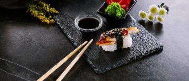 Lezzetli Japon yemekleri, sıcak deniz ürünleri ile suşi closeup. Geleneksel oryantal mutfağı restoran menü öğesi. Doğu mutfağı. Ahşap tabakta pirinç ve sos ile lezzetli balık rulo. Asya meze, unagi maki