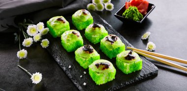 Tobiko havyar, peynir ve wasabi kap ile pişmiş rulo. Suşi bar, Japon mutfağı restoran menü öğesi. Geleneksel doğu mezesi, asya mutfağı. Ahşap tabakta lezzetli gurme atıştırmalık yakın çekim