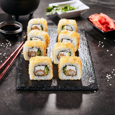 Krem peynir, kral karides, chuka yosun salatası ve nori ile sıcak gevrek ebi tempura maki suşi rulo Makro atış. Doğal siyah taş kayrak arka plan closeup üzerinde derin kızarmış uramaki rulo seti