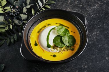 Ricotta Cheese Mus Close Up ile Nefis Kabak Kremalı Çorba. Doğal Siyah Taş üzerinde Karanlık Bitkilerin Şık Süslemeleri ile Güzel Yaratıcı Moleküler İtalyan Çanak