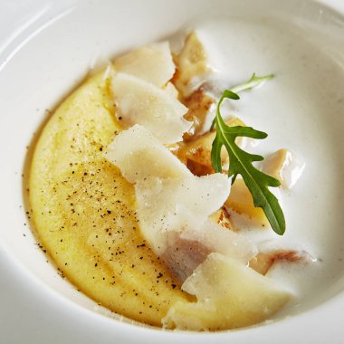 Porcini Mantar ve Pecorino Peynir Close Up ile Ev Yapımı İtalyan Krem Polenta Zarif Hizmet Beyaz Restoran Tabağı. Doğal Siyah Mermer Arka Plan Üzerine Haşlanmış Mısır Unu Fine İtalyan Çanak