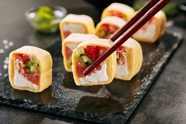 Pałeczki Holding Wędzony Łosoś Burrito Lub Tortilla Sushi Rolls Zbliżenie — Zdjęcie stockowe