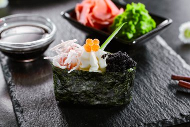 Günkan yengeç eti ve masago havyar ile. Asya mutfağı restoran yemeği, menü öğesi. Geleneksel oryantal yemekler, ulusal japon yemekleri. Lezzetli suşi, ahşap tabakta deniz ürünleri closeup