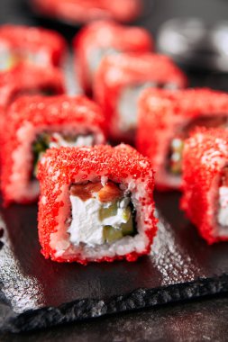 Pirinç, krem peynir, somon, salatalık, uçan balık havyar ve nori yakın ile Alaska somon uramaki suşi restoran menüsü. Kırmızı tobiko closeup ile Japon gıda uramaki rulo Makro atış