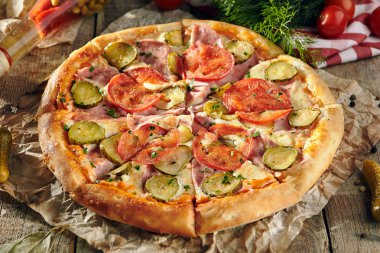 Pizza restoran menü - lezzetli taze Pizza domates, jambon ve salatalık turşusu ile. Pizza malzemelerle rustik ahşap masa üzerinde
