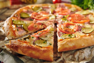 Pizza restoran menü - lezzetli taze Pizza domates, jambon ve salatalık turşusu ile. Pizza malzemelerle rustik ahşap masa üzerinde