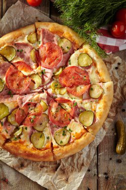 Pizza restoran menü - lezzetli taze Pizza domates, jambon ve salatalık turşusu ile. Pizza malzemelerle rustik ahşap masa üzerinde