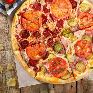 Pizza salam ile ikiye başka bir şeydir - ham salatalık turşusu ve sebze ile ahşap kurullarında dilimlenmiş domates ile