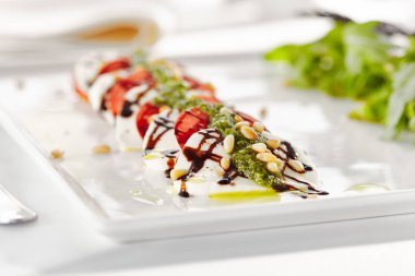 Gurme, restoran, lezzetli akşam yemeği - Caprese Salatası yakın. Domatesli Salata, Mozzarella Peyniri, Balzamik. Pesto Soslu Salata Sosu ve Roket Salatası