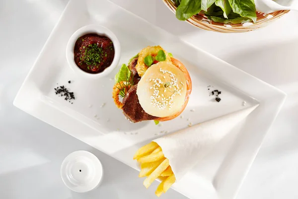 美味的晚餐食物 三明治与牛肉和油炸洋葱环 番茄和黄瓜的特写 配上法式炸薯条 — 图库照片