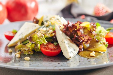 Dilimlenmiş armut, gorgonzola peyniri, yeşillik ve çam fıstığı ile Salata