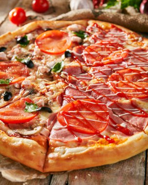 Pizza yarım tavuk ve mantar ve Yeşiller, diğer yandan - jambon ve sos ile. Rustik ahşap arka plan üzerinde taze sebze ile