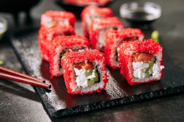Pirinç, krem peynir, somon, salatalık, uçan balık havyar ve nori yakın ile Alaska somon uramaki suşi restoran menüsü. Kırmızı tobiko closeup ile Japon gıda uramaki rulo Makro atış